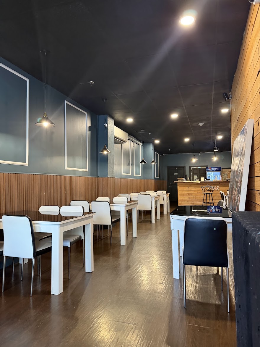 Delhi Darbar dining room with white chairs, wooden walls and pendant lighting